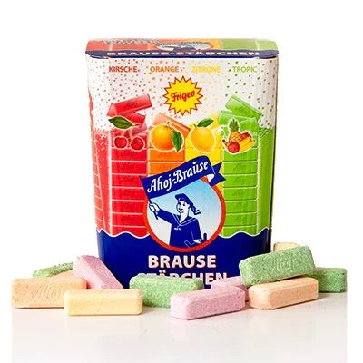 Colorful assorted fruit-flavored sherbet candy tablets with a decorative tin container.