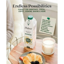 Elmhurst unsweetened milked oats carton with croissant and berries, perfect for smoothies, cereal, coffee, baking