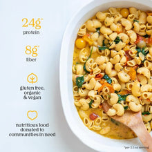 Gluten free vegan pasta with spinach and cherry tomatoes in a white dish, high protein and fiber.