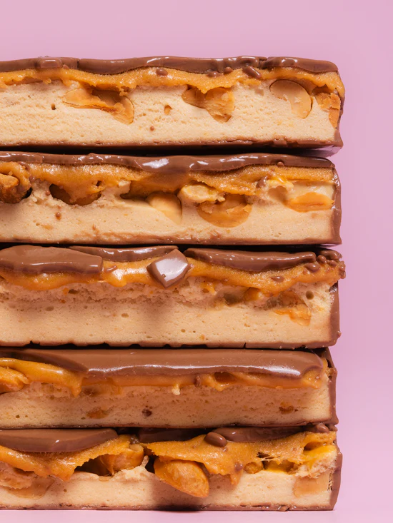 Barebells Salted Peanut Caramel soft bar cross section showing peanut caramel filling and chocolate shell