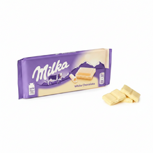 Milka White Chocolate bar with Alpine milk, broken pieces beside purple packaging