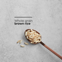 Whole grain brown rice puffs in a wooden spoon on a textured surface