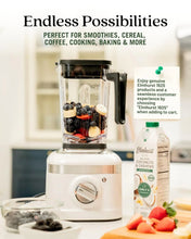 White blender with fresh berries and banana, perfect for smoothies, cereal, coffee, cooking, baking — Elmhurst 1925 milk nearby