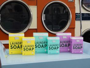 Assorted boxes of ultra concentrated laundry soap powder on a laundry cart by washing machines