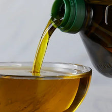 Vegetable cooking oil being poured into a glass bowl, kitchen ingredient close-up