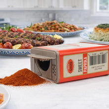Sweet Paprika spice from Szeged, vibrant red powder spilled beside box, perfect for seasoning grilled meats and dishes