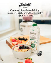 Elmhurst unsweetened coconut & cashew milk carton beside a berry smoothie bowl with granola and fresh fruit