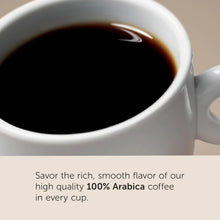 Close-up of a white coffee cup filled with black 100% Arabica coffee, smooth surface visible.