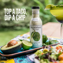 Briannas Creamy Cilantro Lime Dressing bottle with avocado, lime, and salad, perfect for tacos or chips