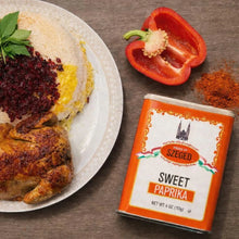 Sweet paprika spice tin with roasted chicken, rice, and red bell pepper on plate
