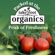 Red organic tomatoes on the vine with 'Peak of Freshness' and 'organics' text overlay.