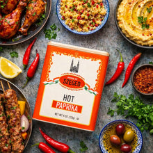 Hot Paprika spice tin surrounded by grilled meats, hummus, olives, and red chilies for flavorful cooking