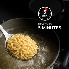 Orzo pasta in spoon over boiling water, ready in 5 minutes — quick meal solution