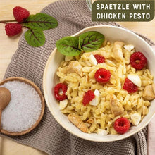 Spaetzle with chicken pesto, fresh raspberries, and herbs in a bowl — gourmet meal ready to serve