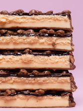 Barebells Creamy Crisp bar cross section showing nougat caramel and crispy chocolate puffs