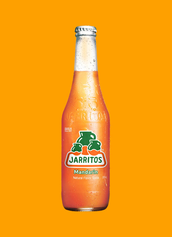 A glass bottle of Jarritos Mandarin soda with condensation, centered against a solid orange background.